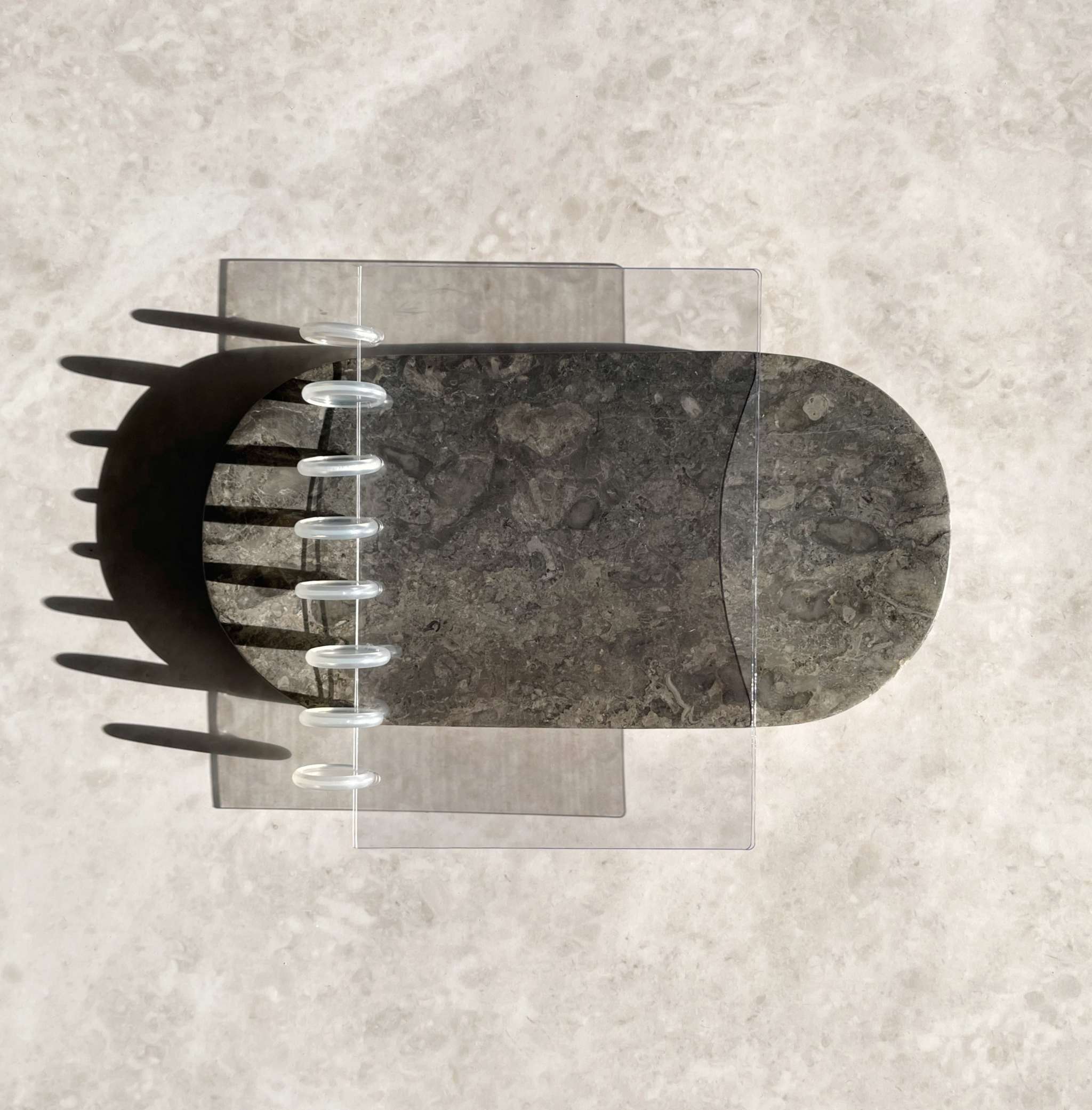 Transparentes Discbound Cover aus robustem Glaskunststoff mit glänzender Oberfläche und vorgelochten Ringen auf hellem Marmorboden