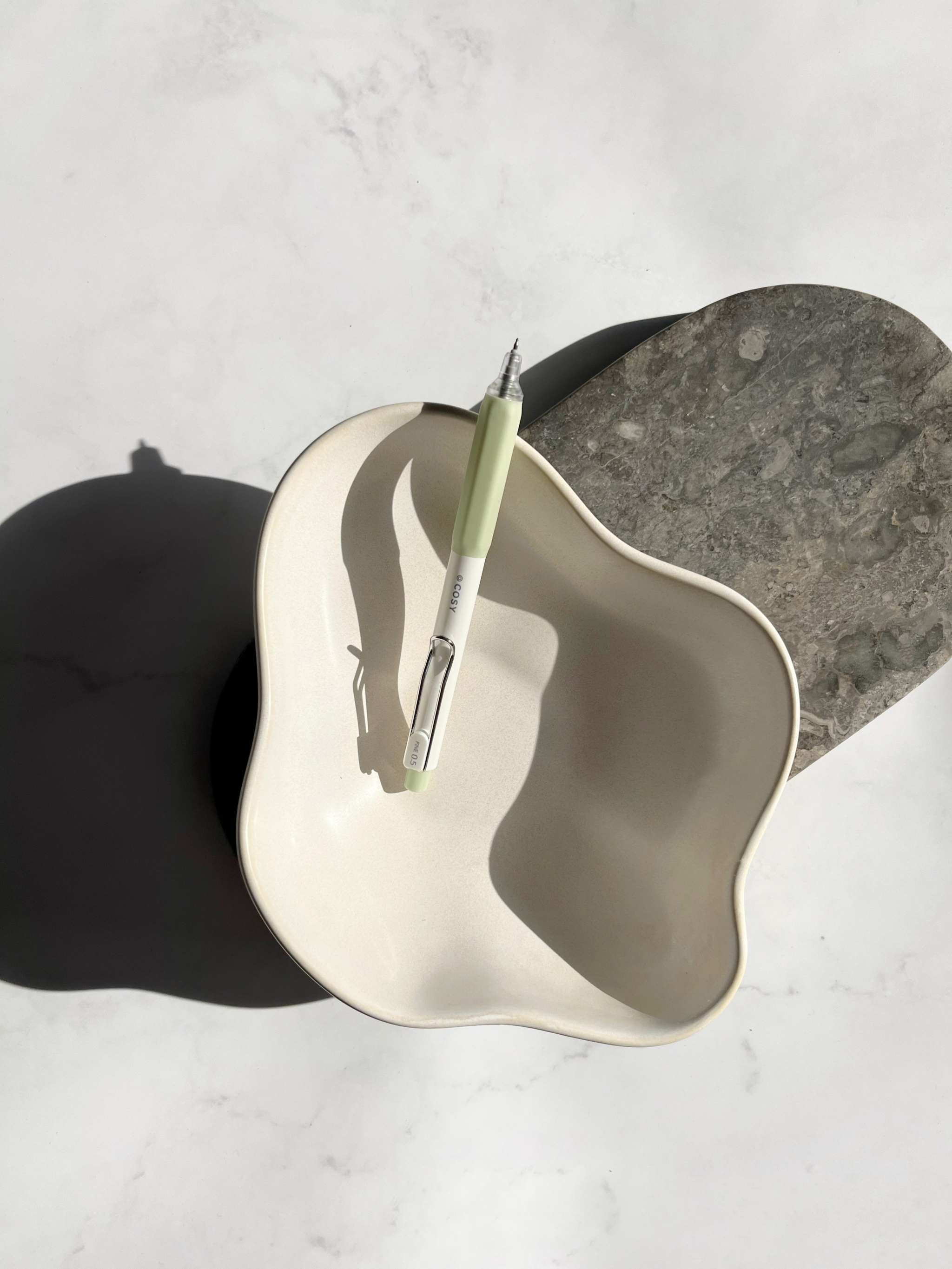 Gelstift «Cosy» 0,5mm mit Nadelspitze und rutschfester Griffzone in stilvollem Design auf weißem dekorativem Teller